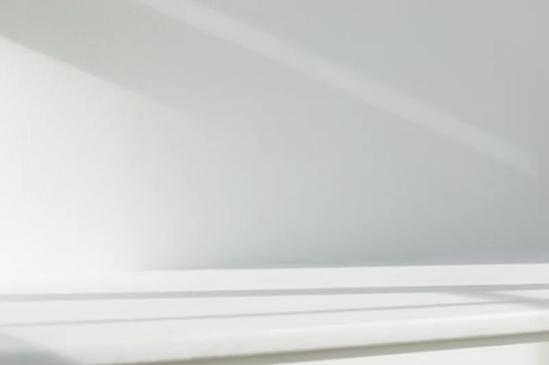Empty white shelf against a smooth white wall in a minimalist interior