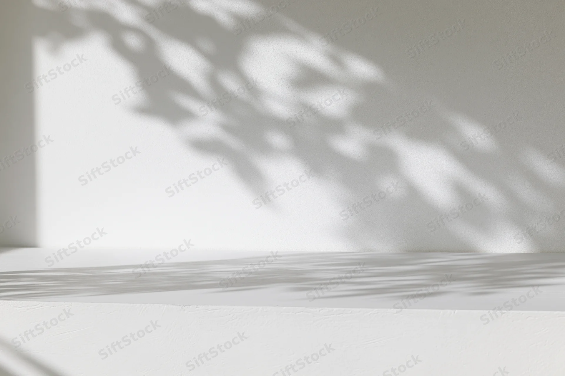 White surface and wall with dappled sunlight shadows in minimalist interior