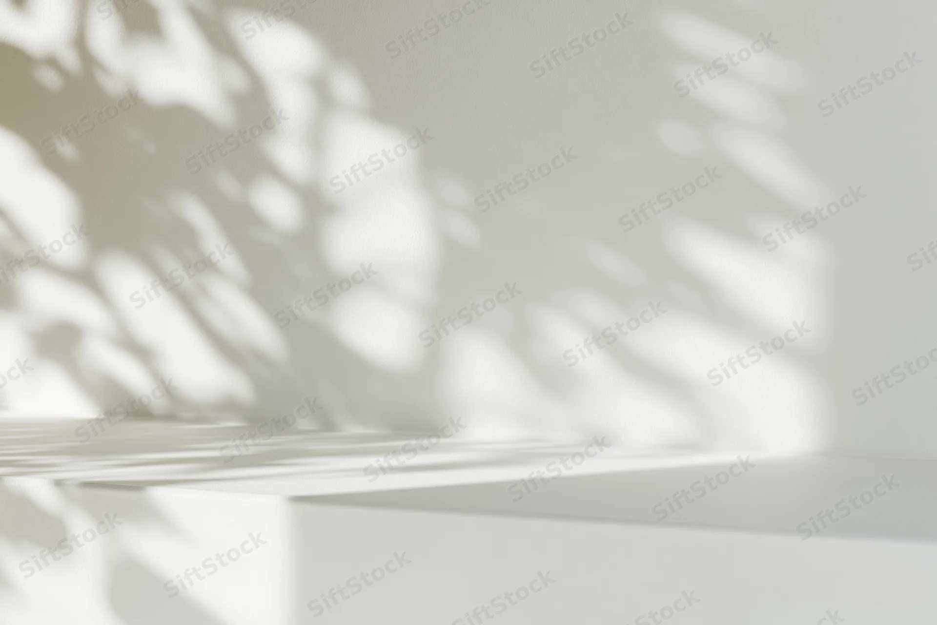 White surface with dappled light shadows on wall in minimalist interior