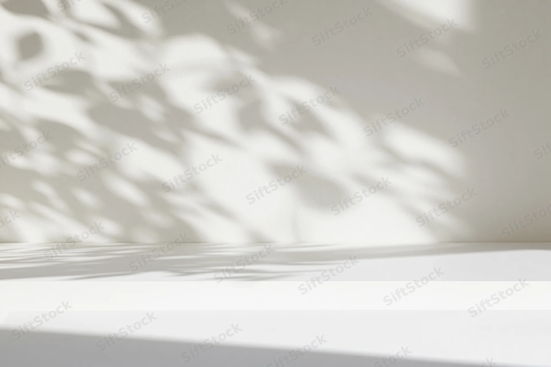 White surface with dappled shadows on a wall in a minimalist interior