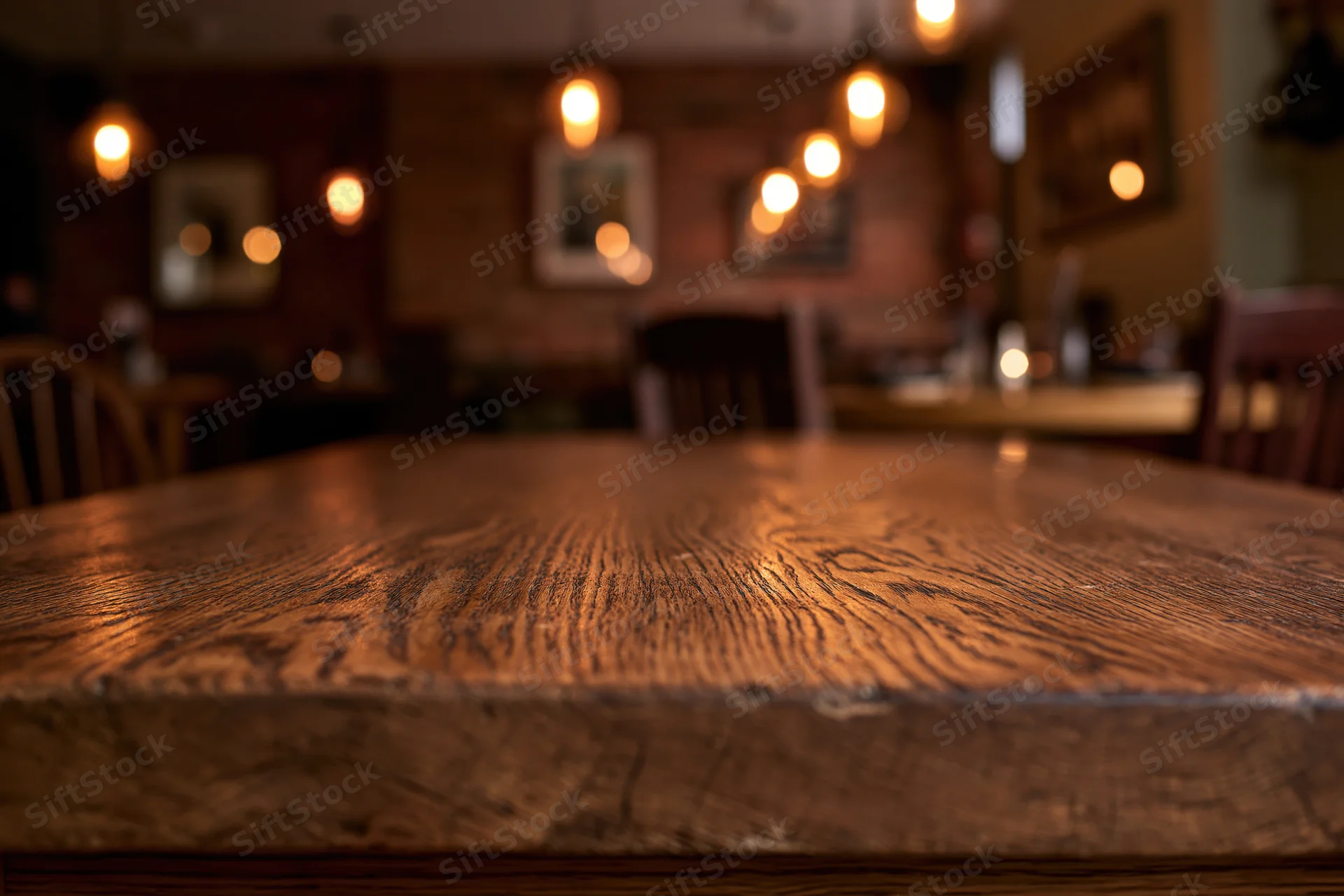 Wooden table surface in focus with blurred restaurant interior behind