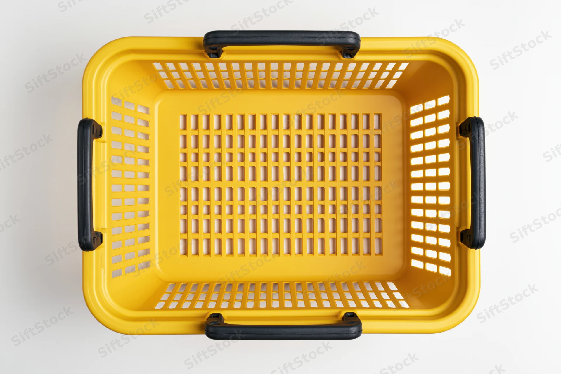 Empty yellow plastic shopping basket with black handles on white background