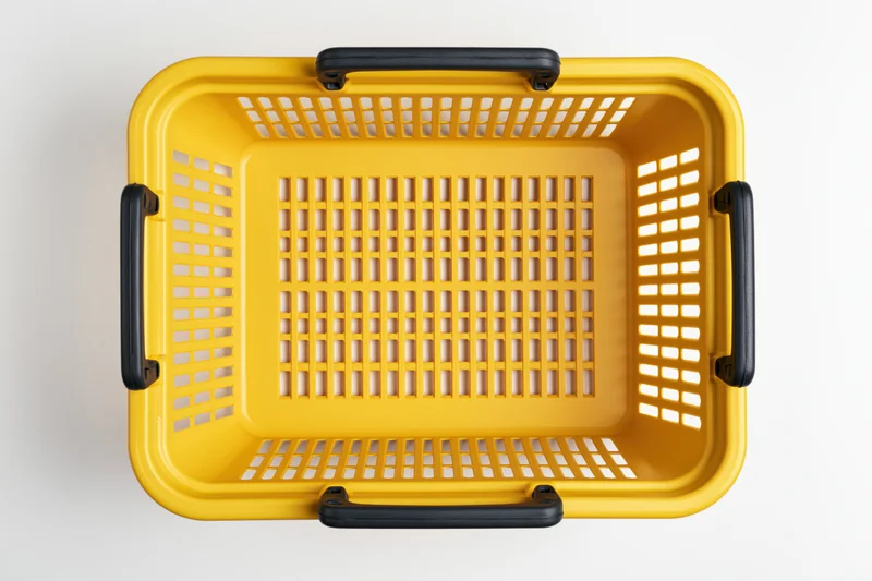 Empty yellow plastic shopping basket with black handles on white background