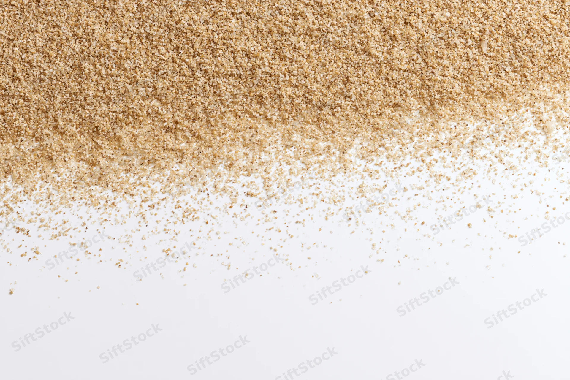 Fine beach sand scattered across a white surface with copyspace below