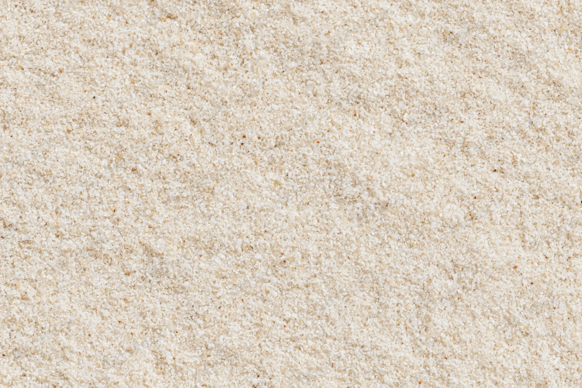 Close-up of fine dry beach sand filling the frame as a textured surface