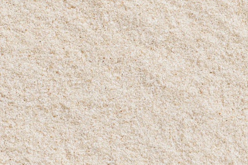 Close-up of fine dry beach sand filling the frame as a textured surface