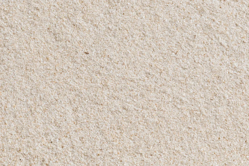 Closeup of fine dry beach sand surface viewed from directly above in flat lay composition