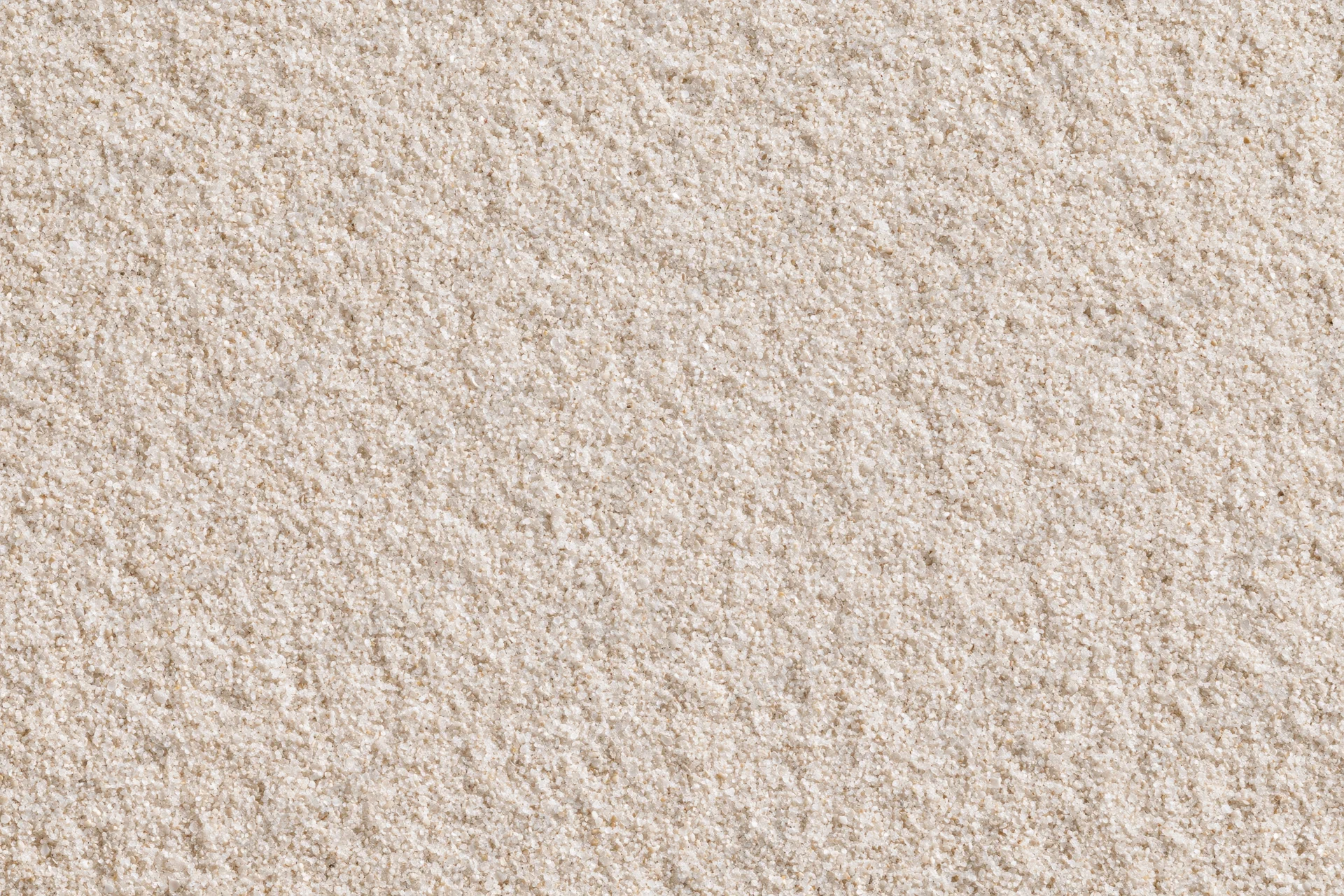 Closeup of fine dry beach sand surface viewed from directly above in flat lay composition
