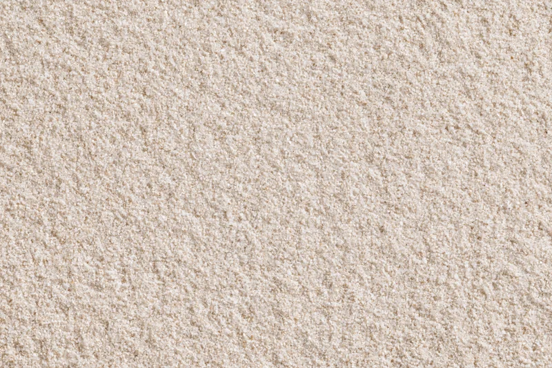 Closeup of fine dry beach sand surface viewed from directly above in flat lay composition