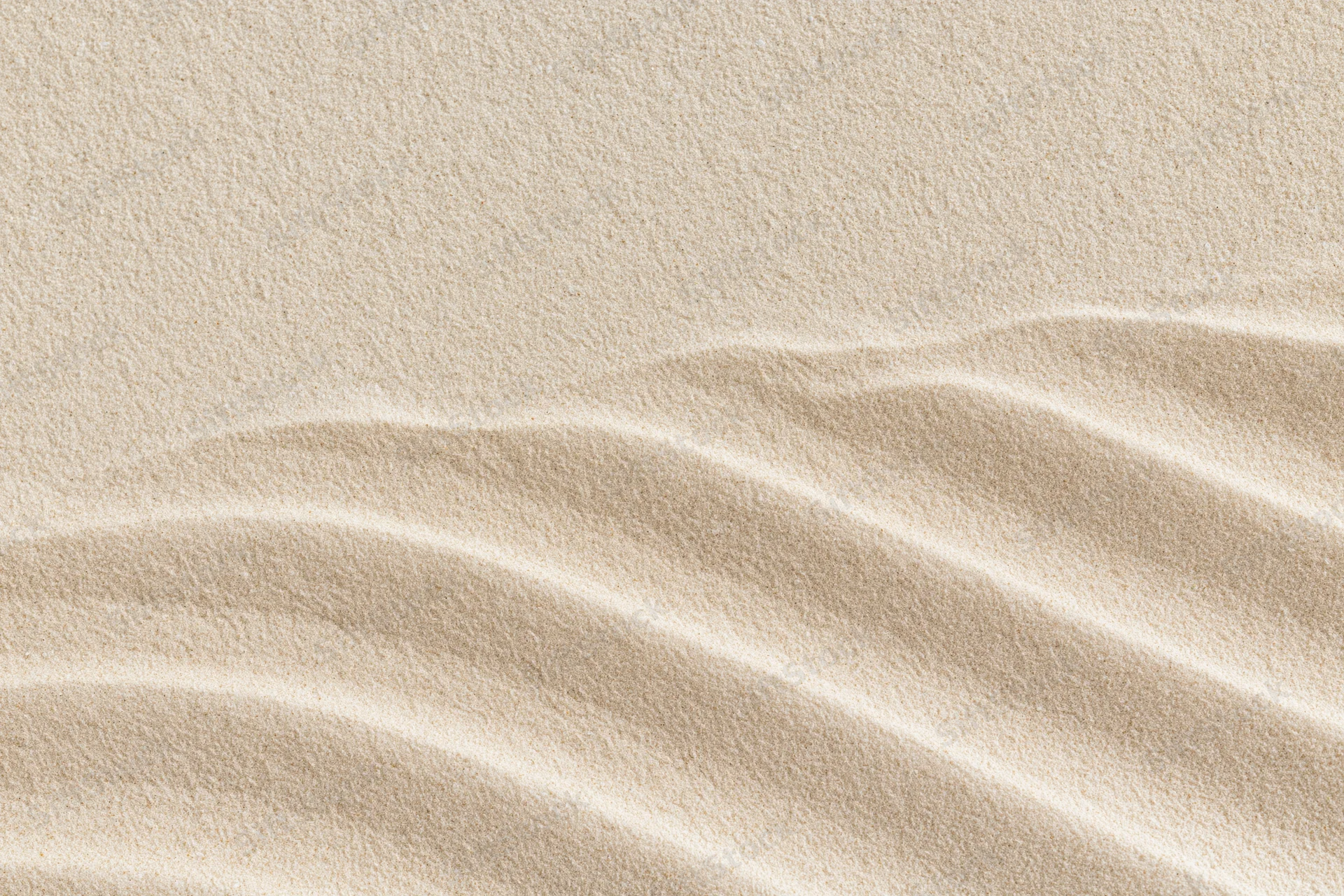 Rippled sand surface with parallel waves under even light