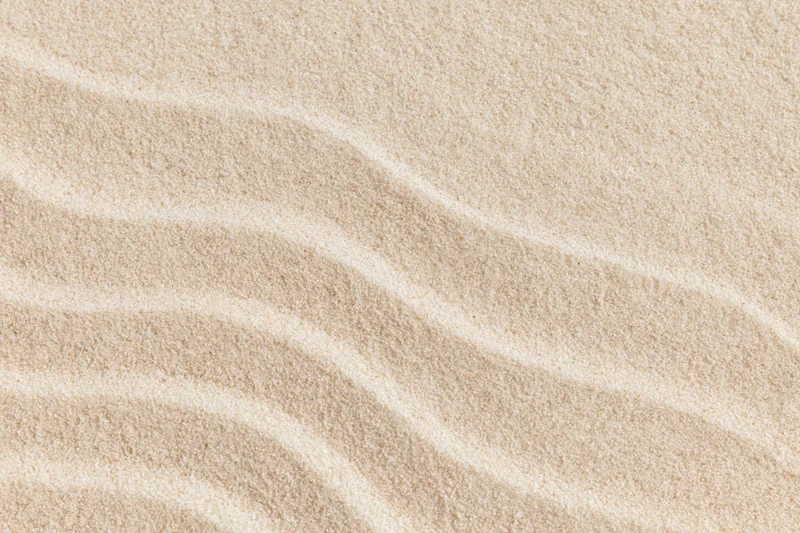 Closeup of fine sand surface with parallel ripples forming a smooth natural pattern