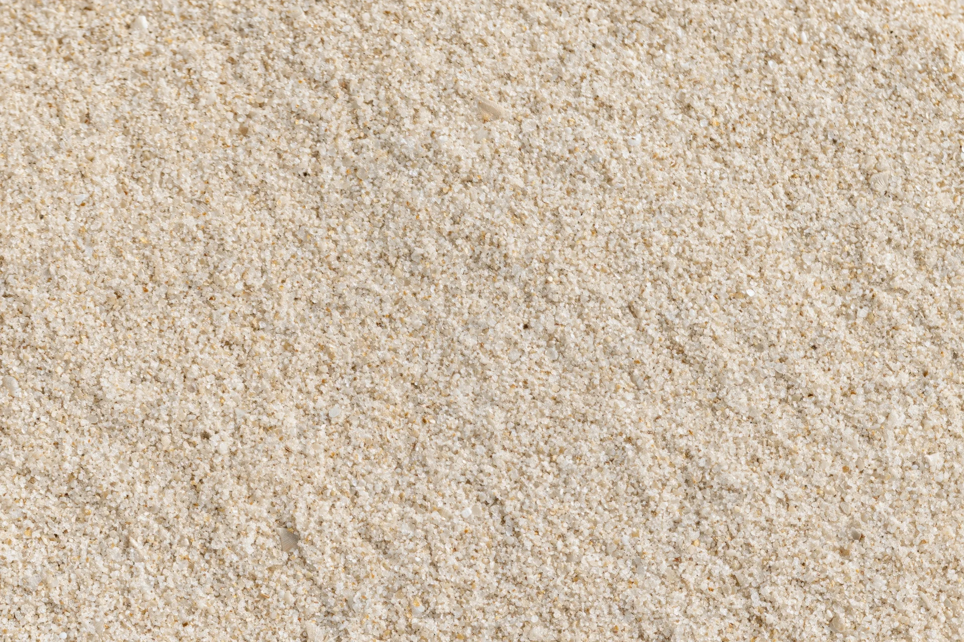 Overhead view of dry beach sand surface filling the frame