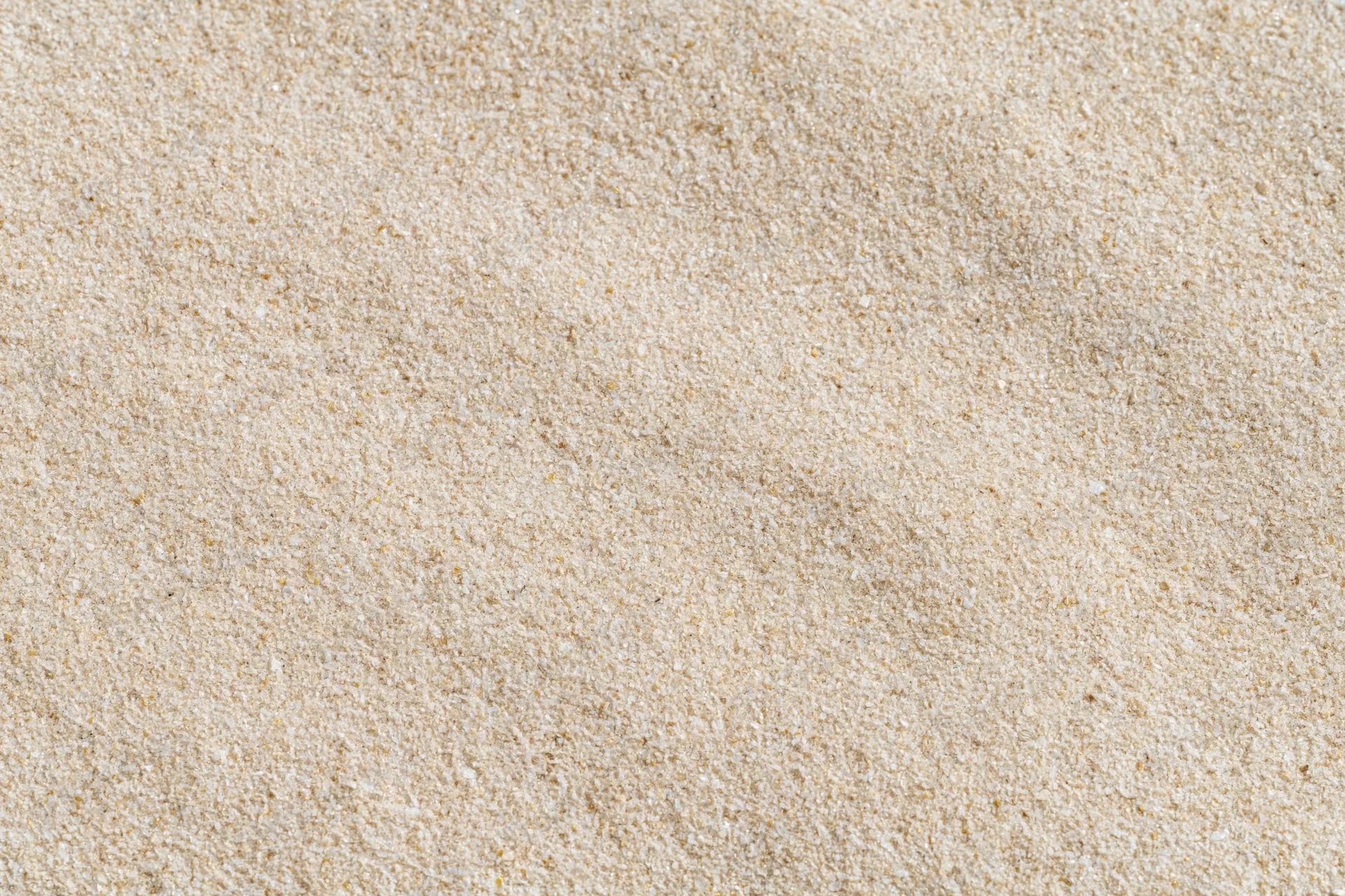 Overhead view of flat dry beach sand surface filling the frame