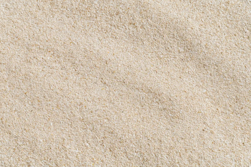 Overhead view of flat dry beach sand surface filling the frame