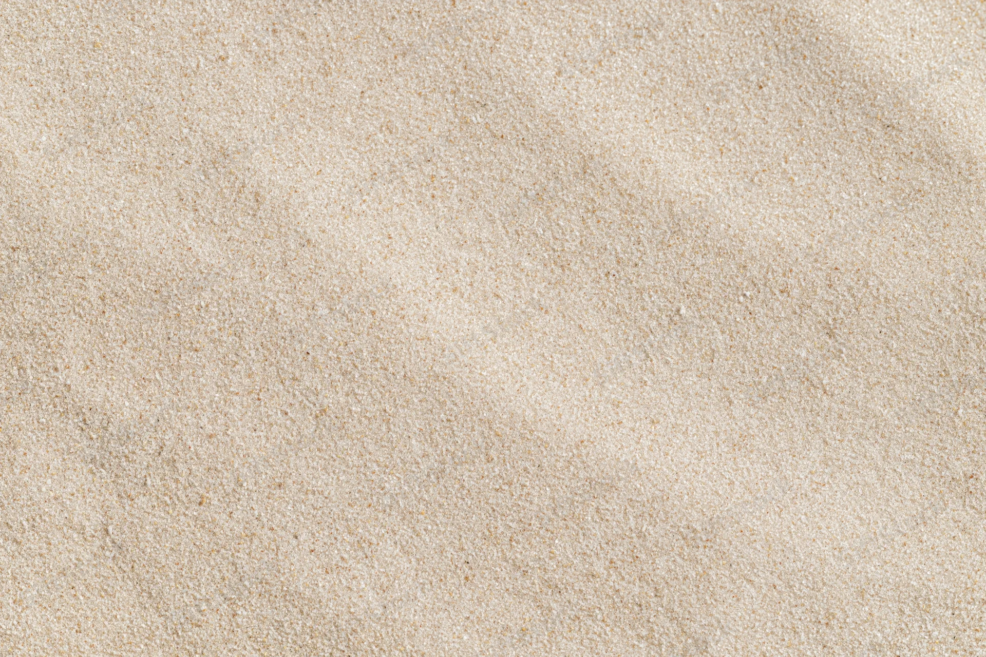 Overhead view of flat dry beach sand surface filling the frame