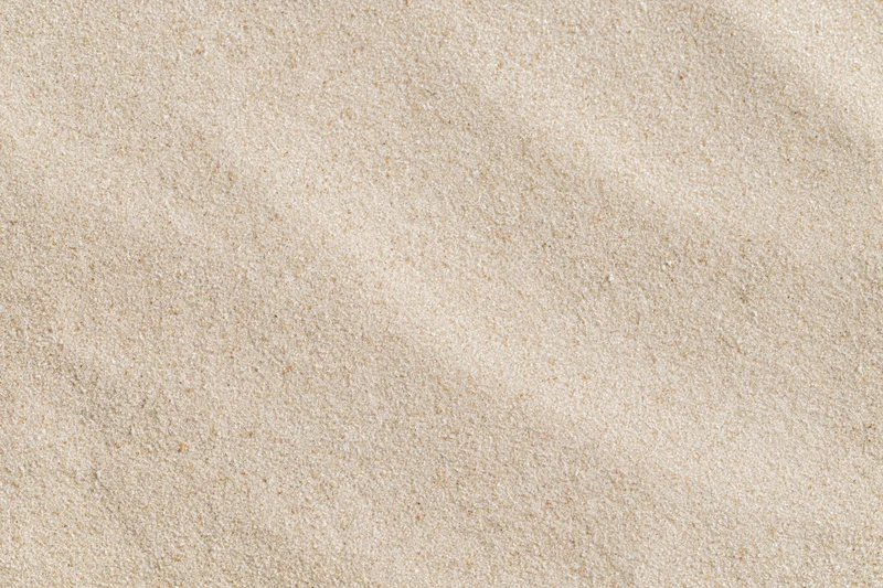 Overhead view of flat dry beach sand surface filling the frame