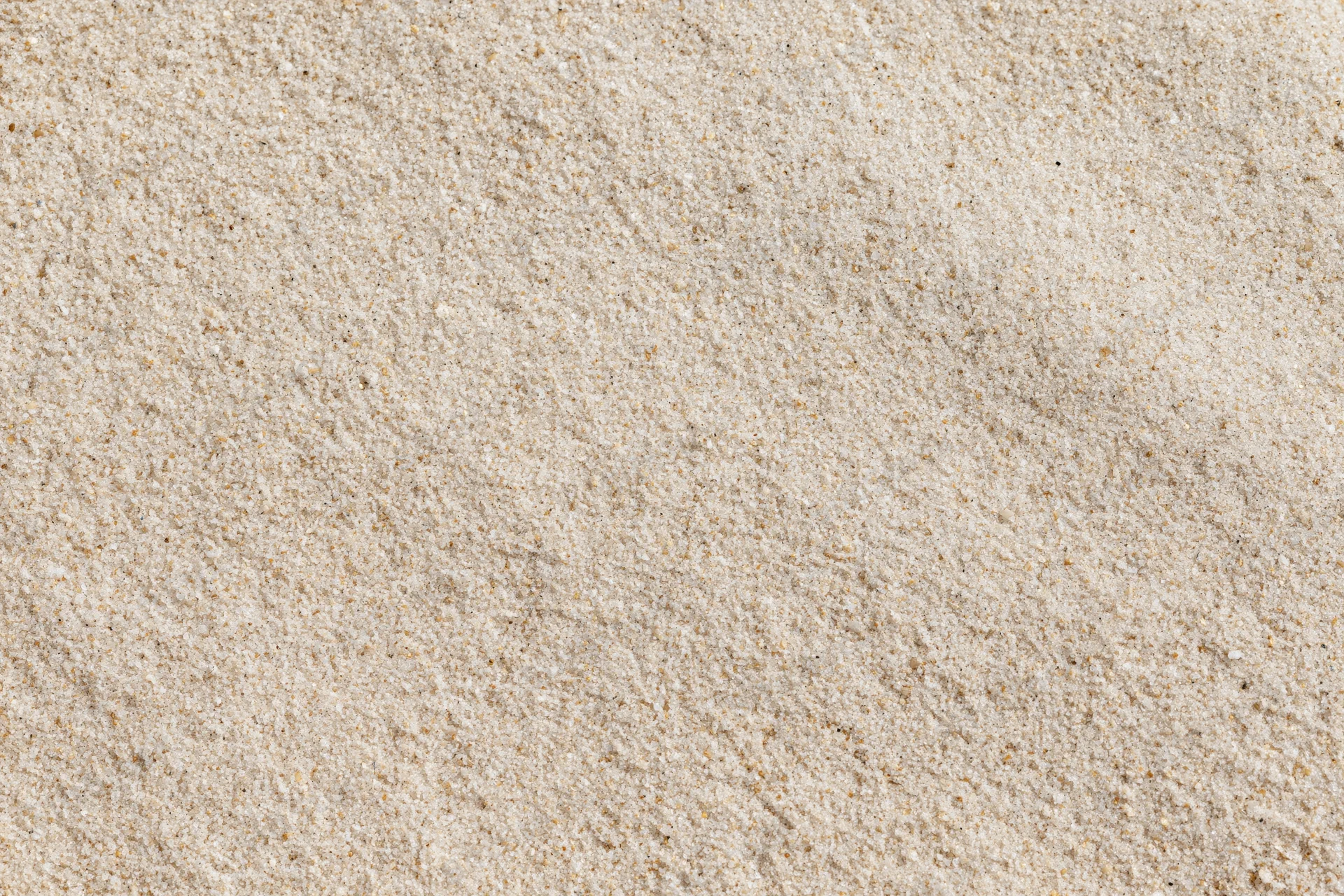 Overhead view of dry beach sand surface filling the frame