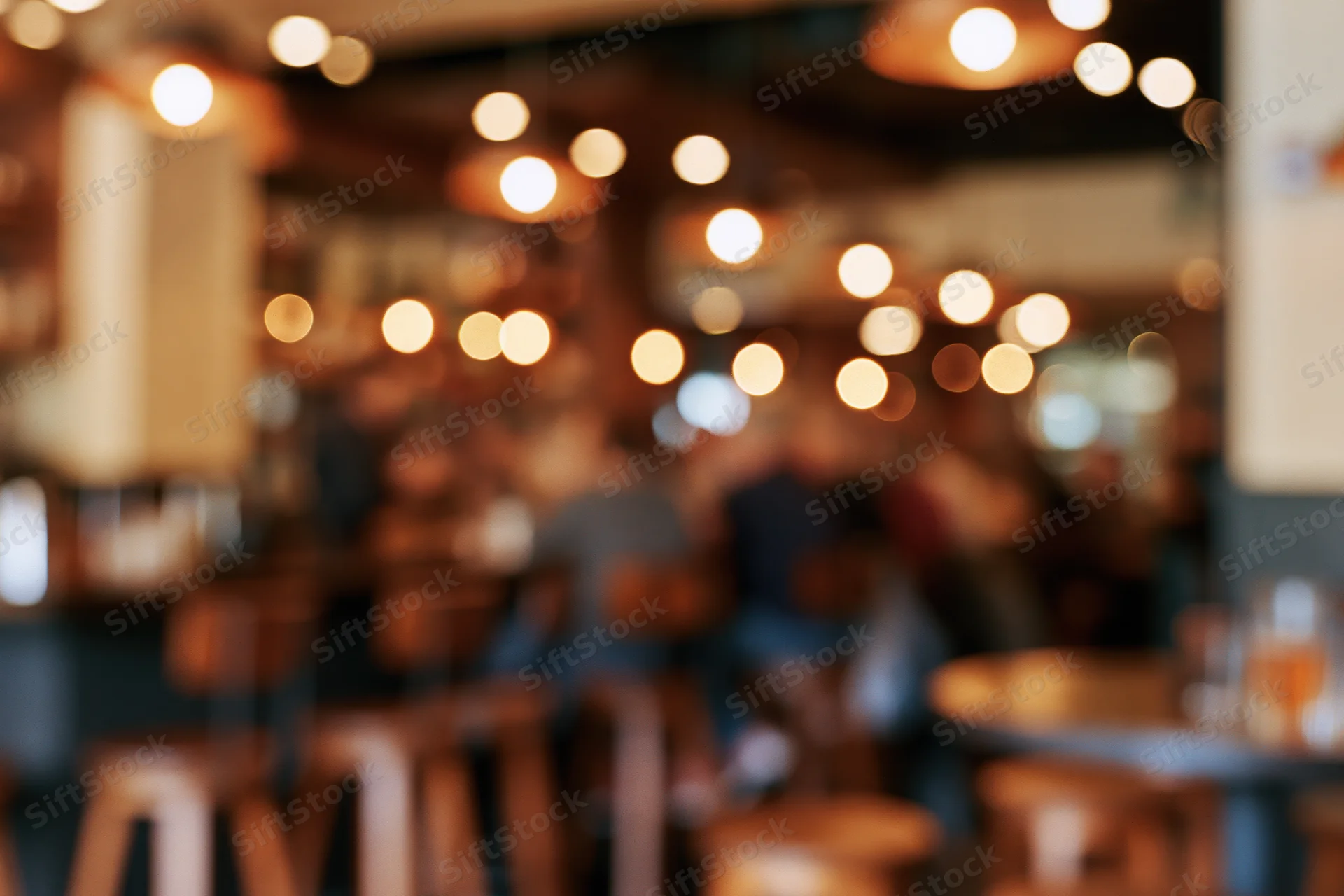 Blurred interior of a casual restaurant with warm lights and wooden furniture