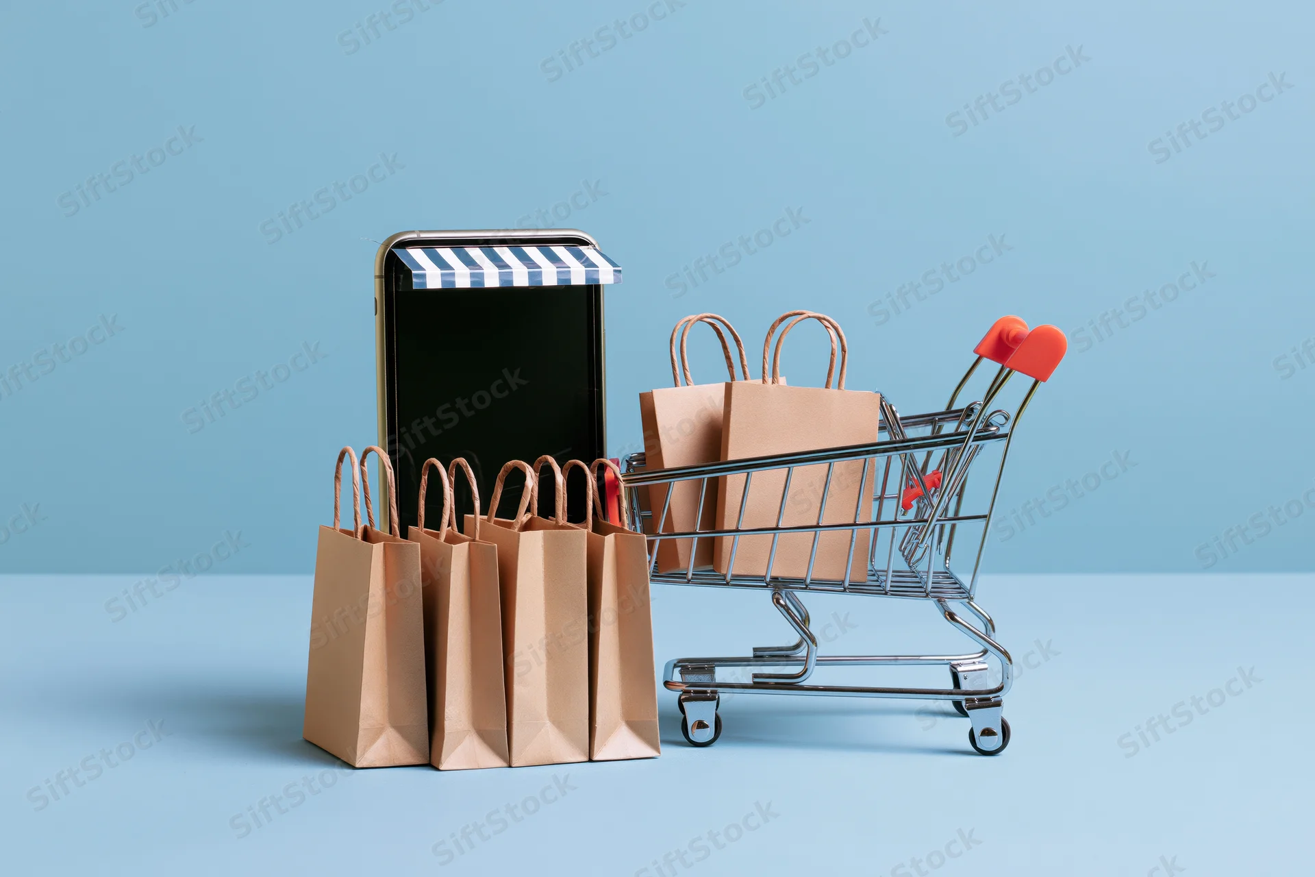 Miniature shopping cart and paper bags beside a smartphone with striped awning on blue background