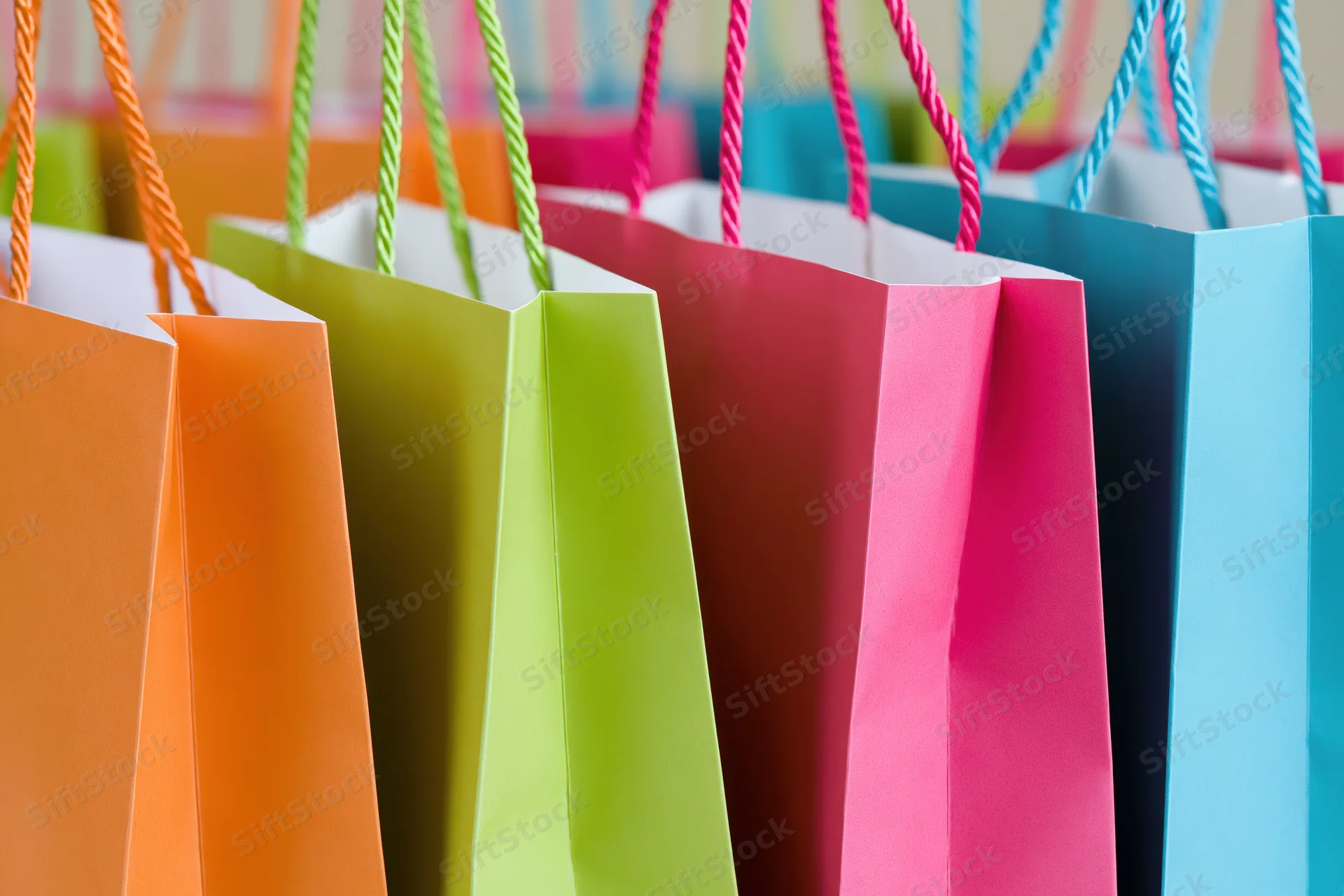 Colorful paper shopping bags standing upright in a row