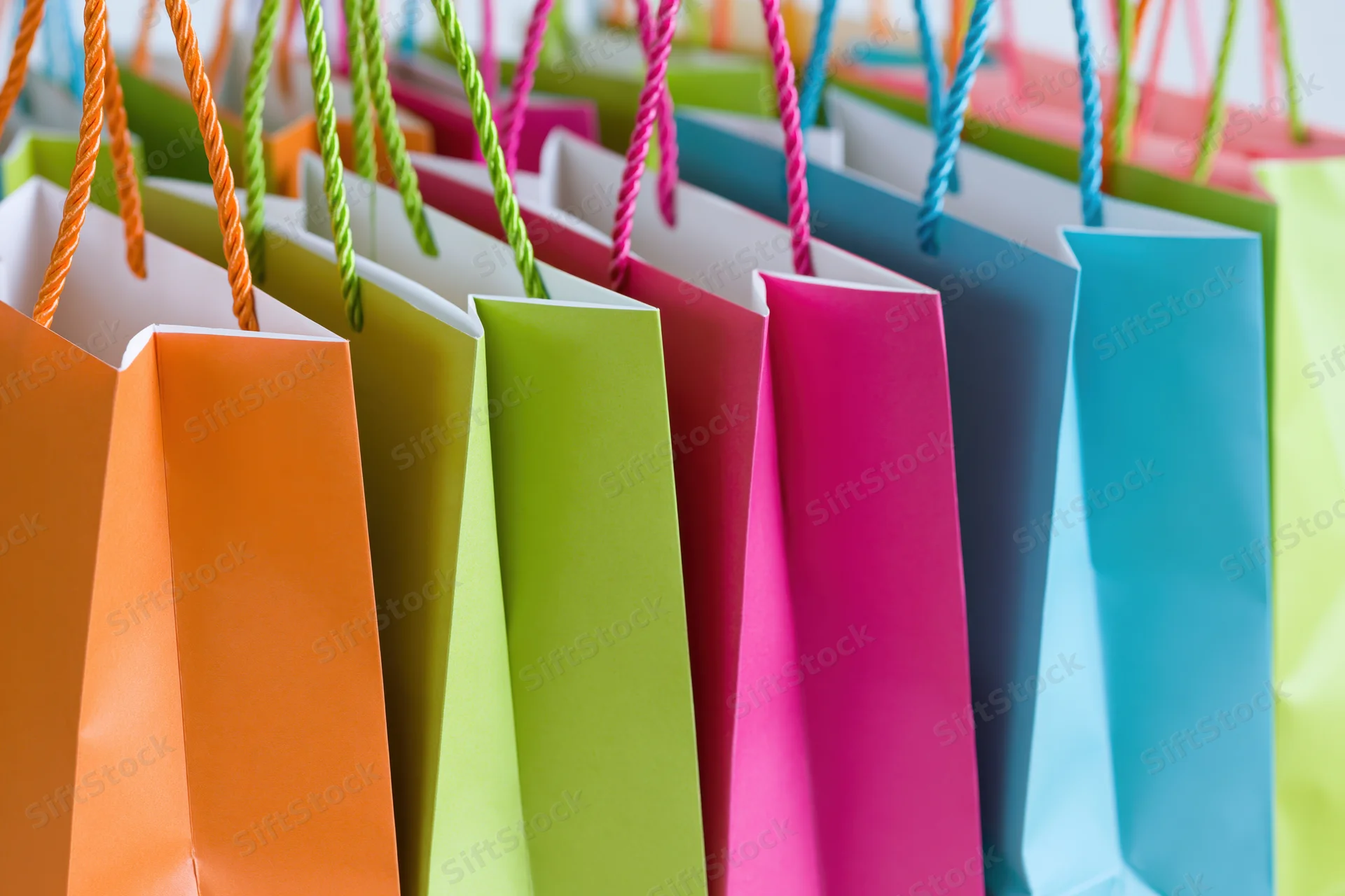 Colorful paper shopping bags standing upright in a row