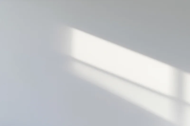 Bright rectangular patch of afternoon sunlight on a smooth white surface