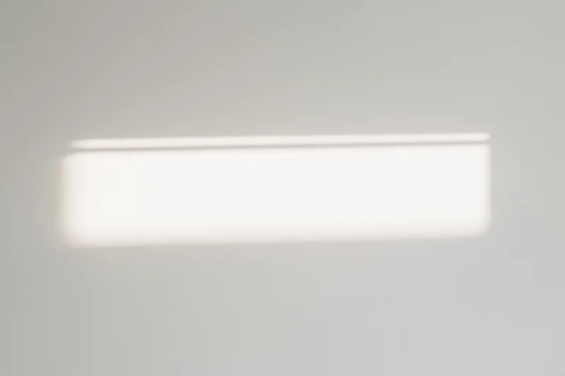 Bright rectangular patch of sunlight on a white ceiling indoors