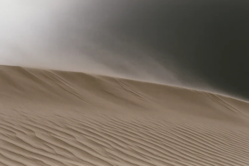 Sand blowing off the crest of a desert dune during a windstorm