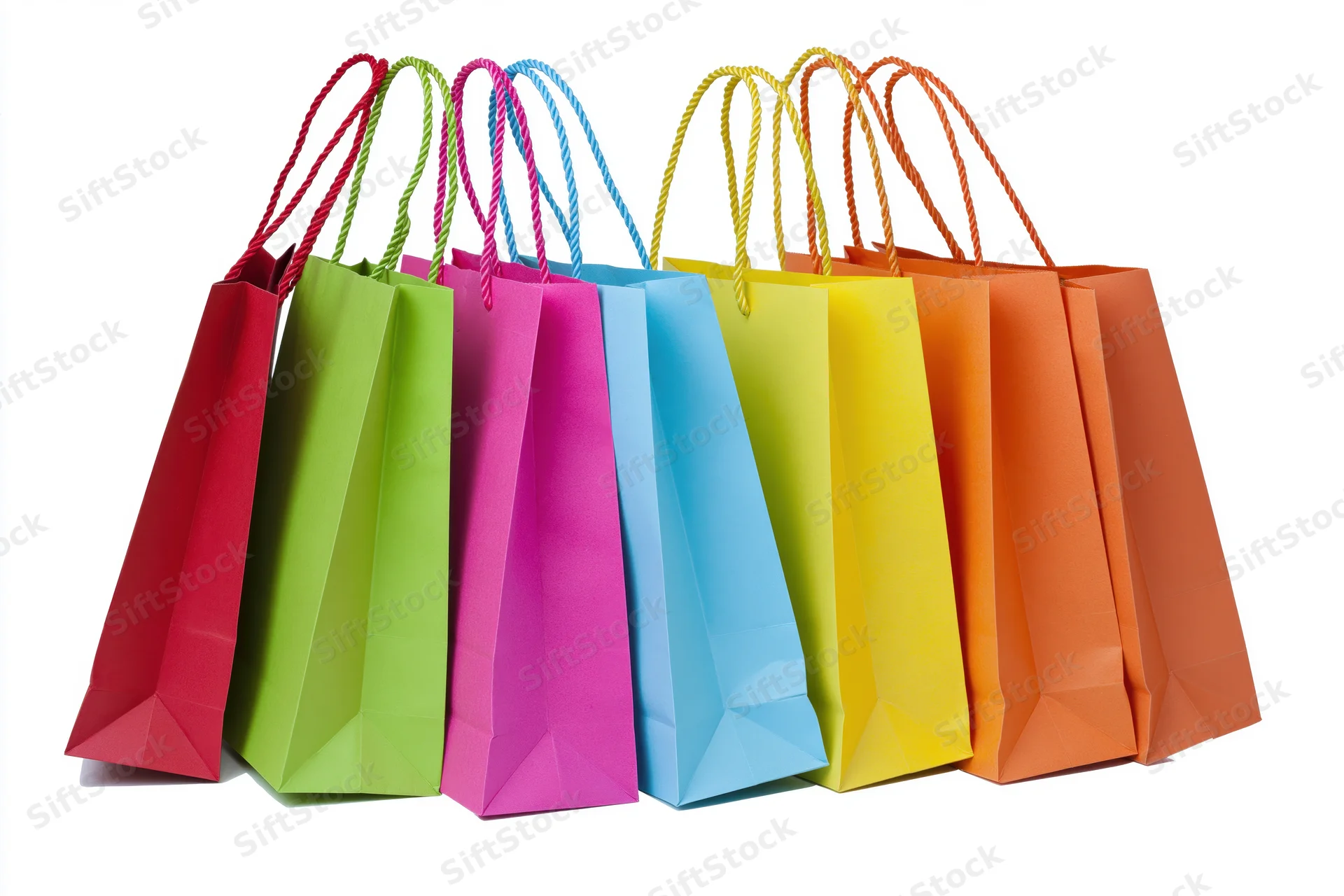Seven colorful paper shopping bags with twisted rope handles arranged in a row on white background