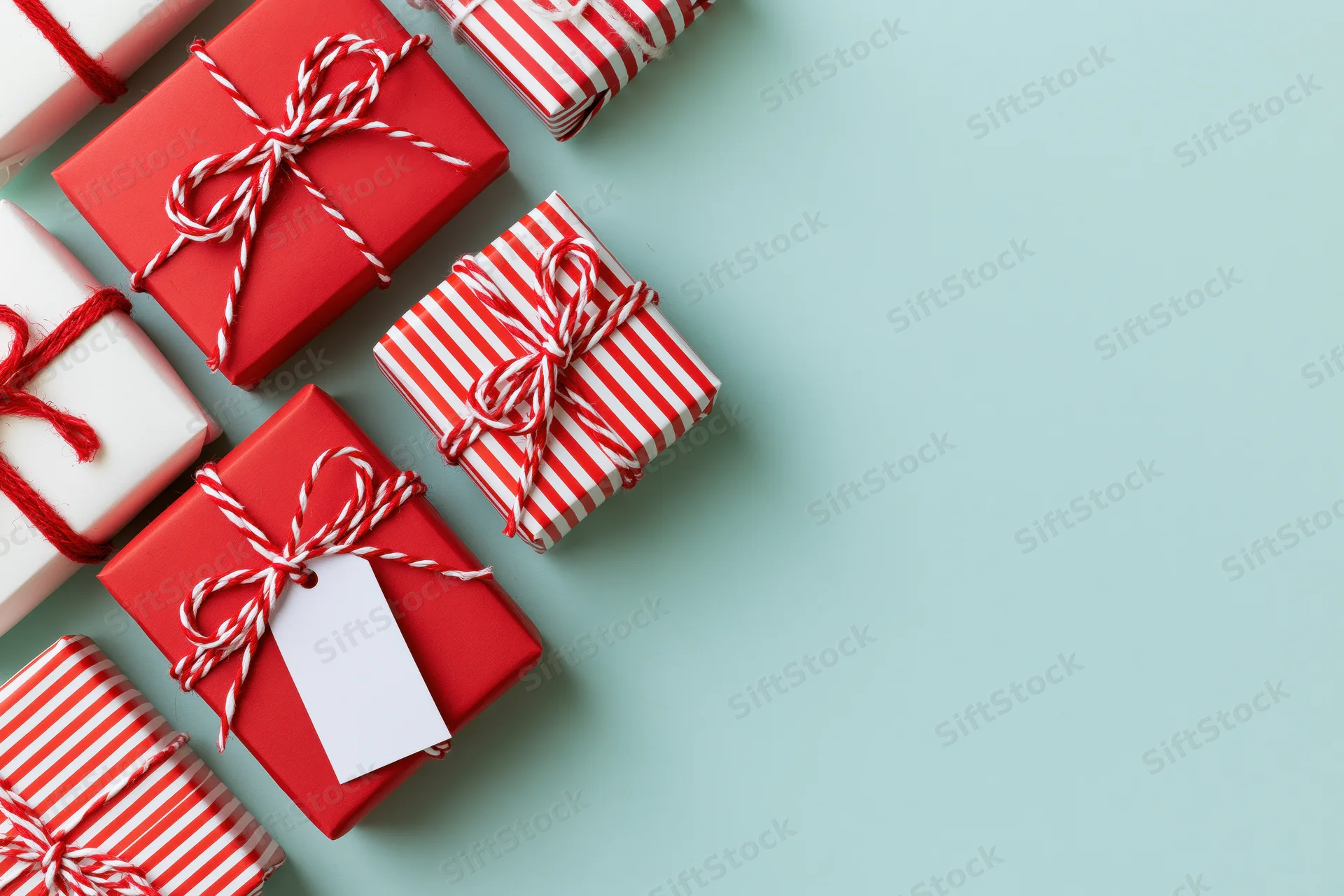 Wrapped gift boxes arranged along the left edge on a mint background with copyspace