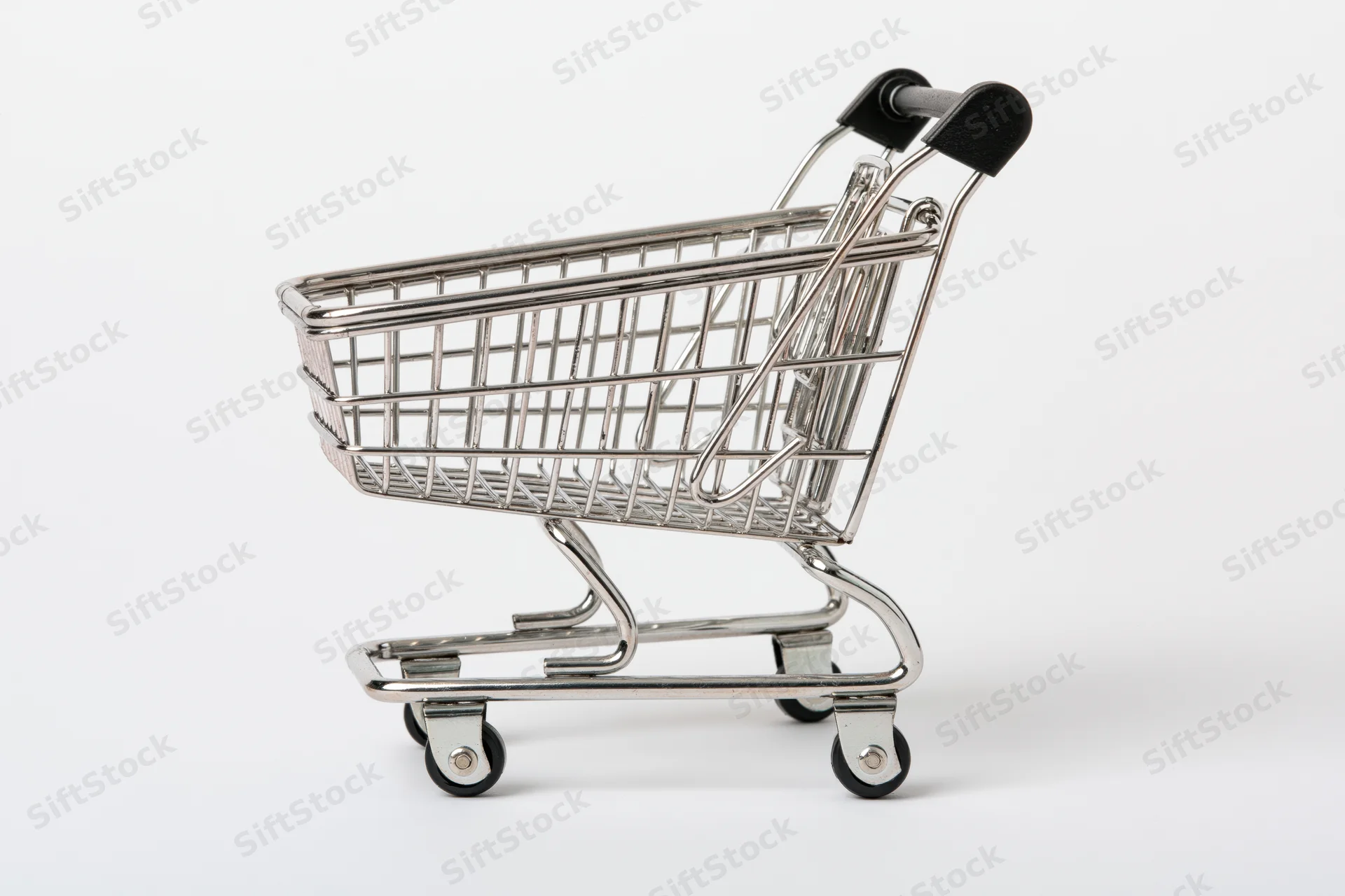 Miniature chrome shopping cart replica viewed from the side on a white background