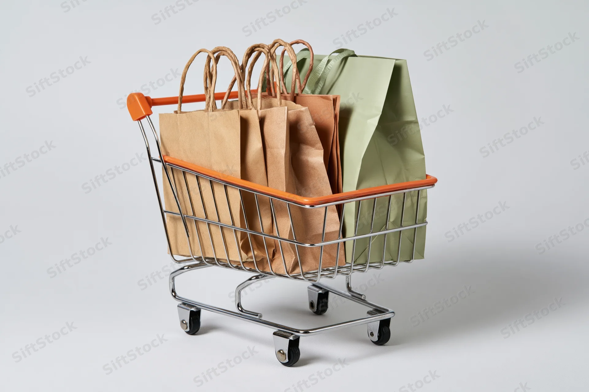 Small metal shopping cart filled with paper bags on white background