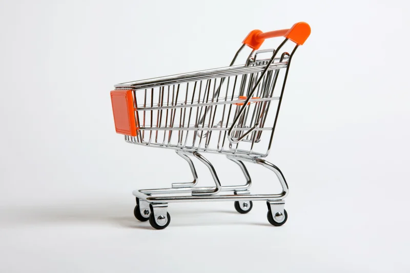 Miniature shopping cart toy empty on white background