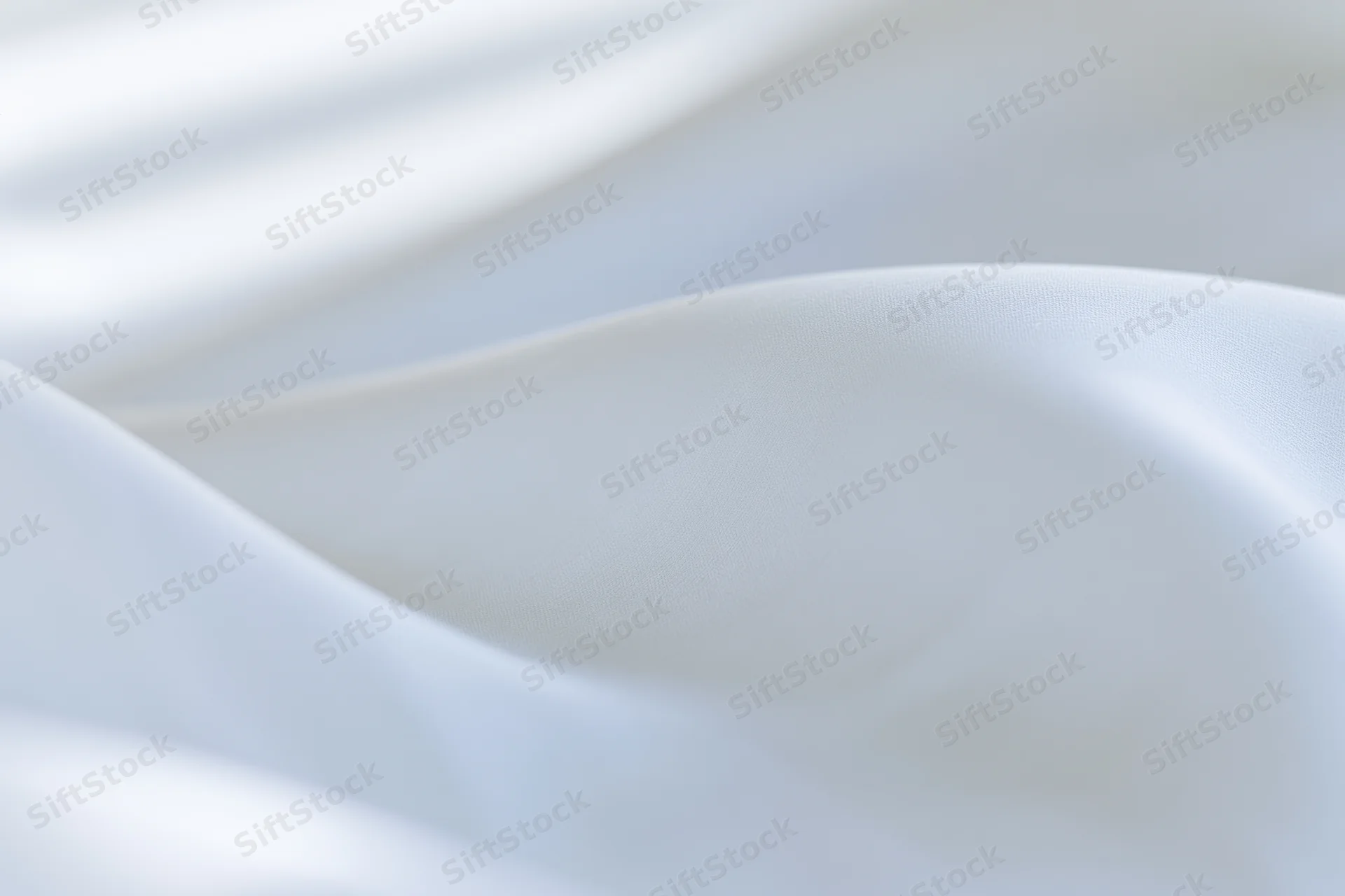 Close-up of flowing white fabric with soft folds and gentle light reflections