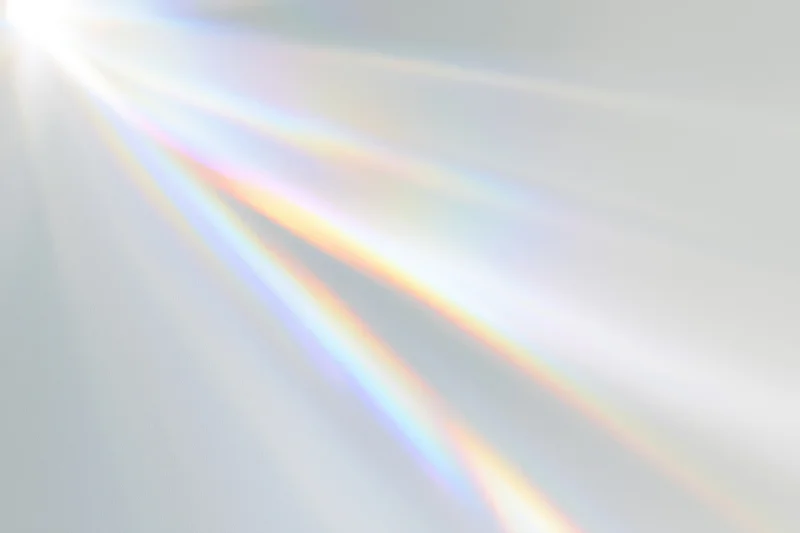 Sunlight refracting through a prism casting a rainbow spectrum across a light surface