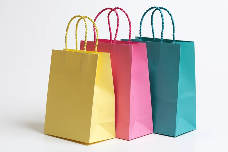Three colorful paper shopping bags grouped together on white background