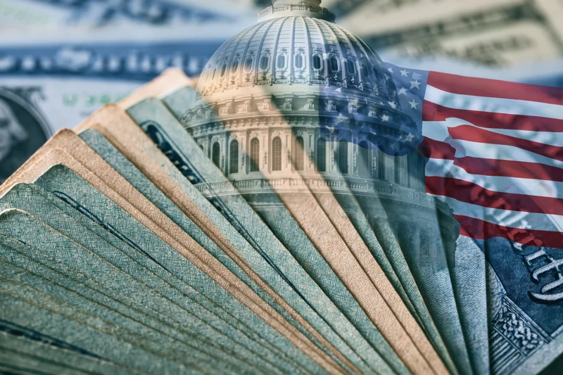 Fan of us dollar bills with transparent overlay of us capitol dome and american flag