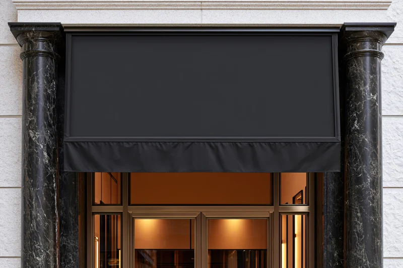 Blank black awning over glass doors flanked by marble columns on upscale retail storefront