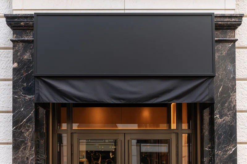 Upscale retail storefront entrance with blank black awning and marble facade