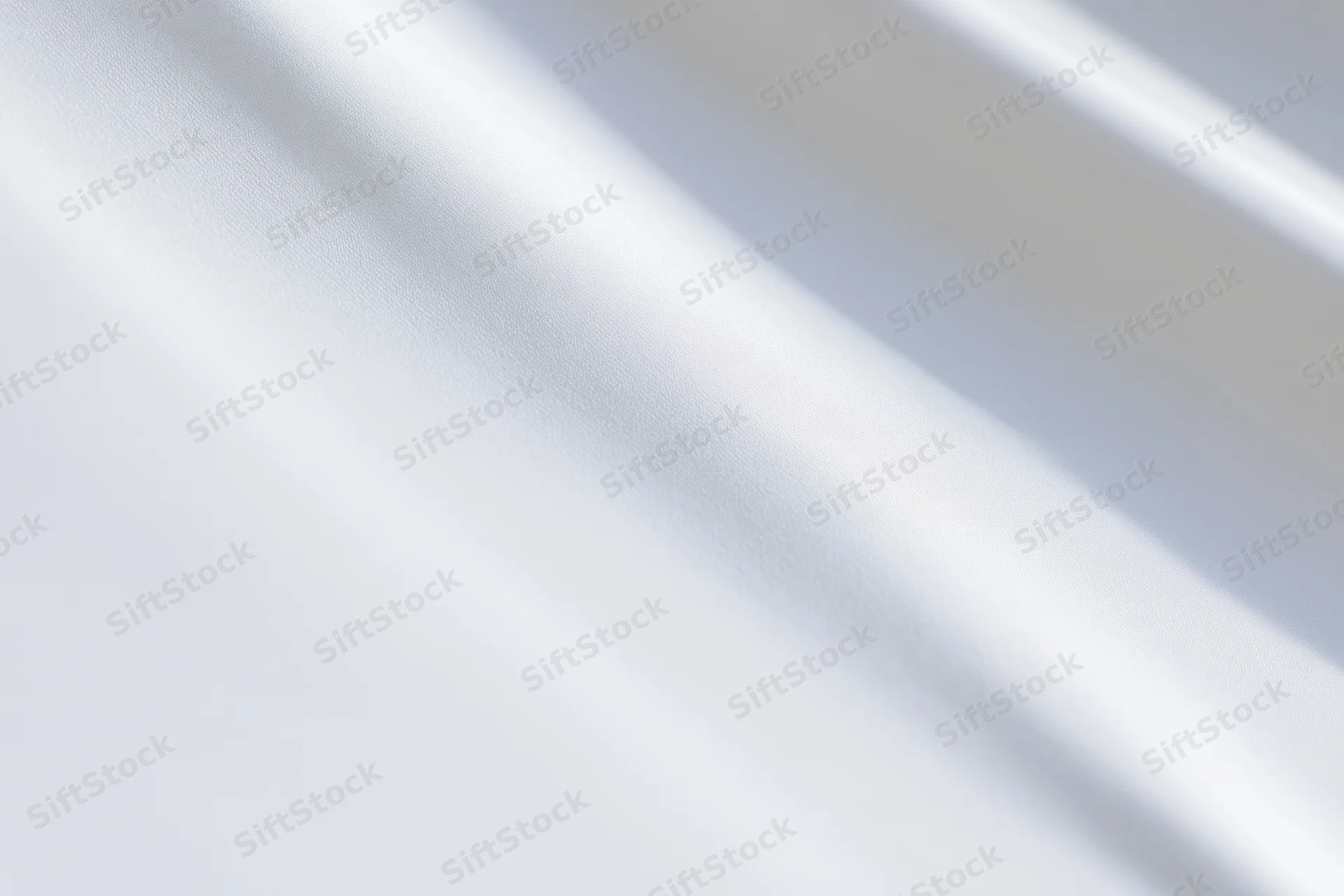 Soft white fabric with diagonal shadows and folds, creating a smooth textured surface