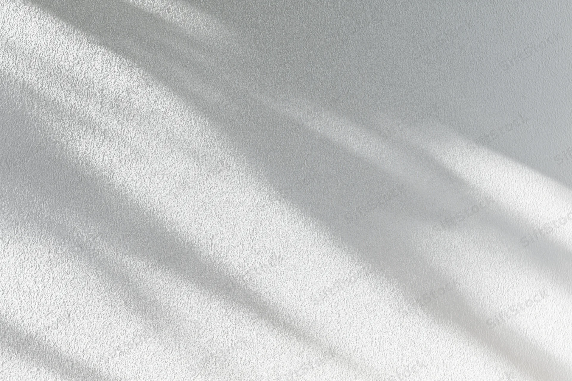 White painted plaster wall with soft diagonal shadows from natural light