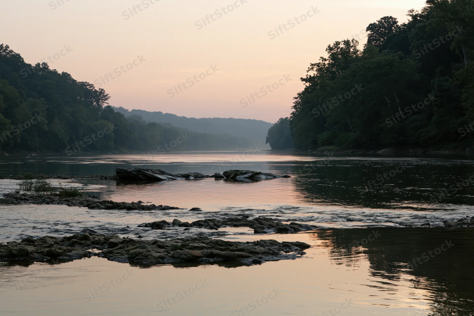 Wide river at dusk with shallow rocky shoals and tree-lined banks reflecting soft twilight light