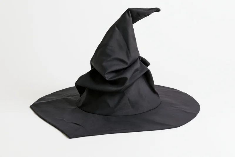 Black fabric witch hat with floppy crumpled pointed crown on white background