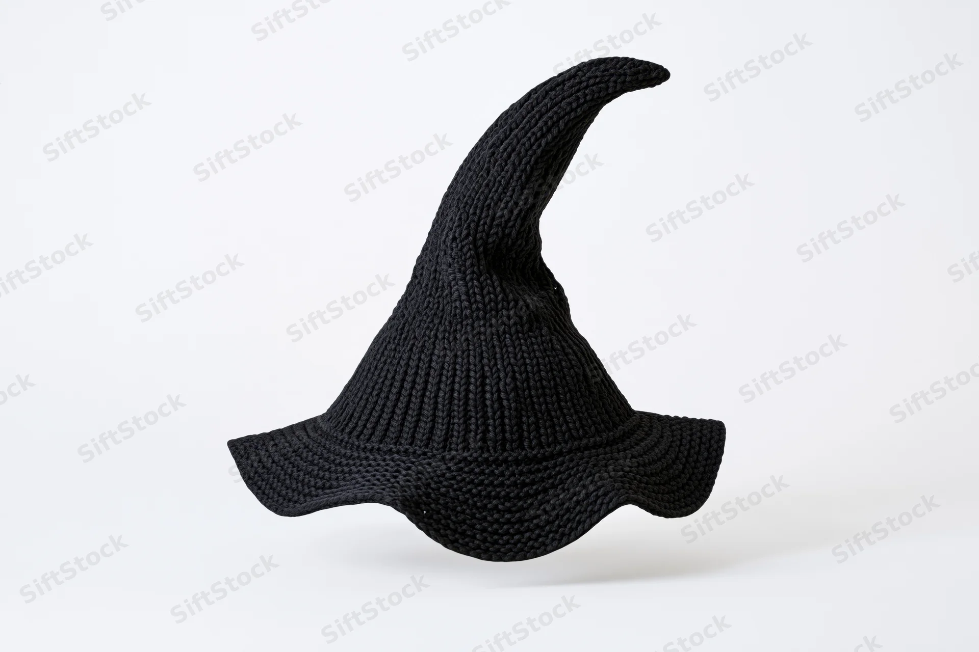 Black knitted witch hat with tall pointed peak isolated on white background
