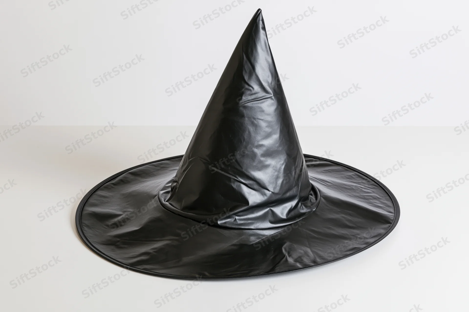Black plastic witch hat resting on white surface with slight tilt