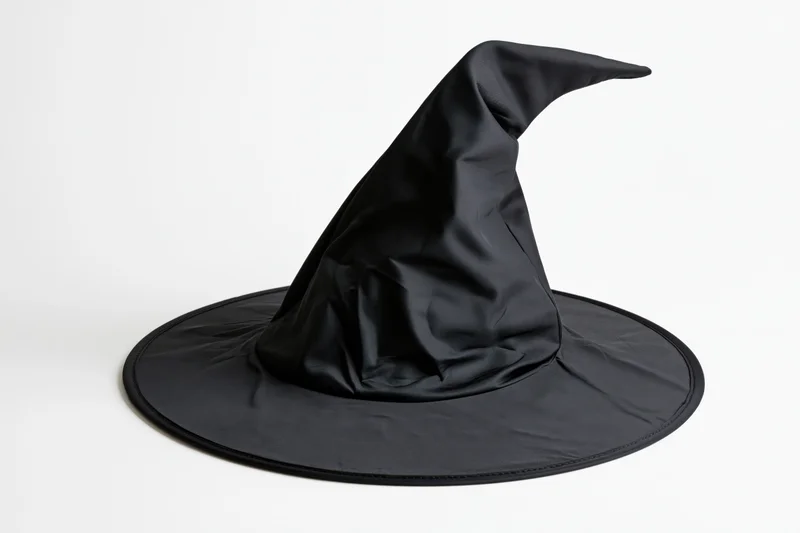 Black pointed witch hat with wide brim and slight bend isolated on white background