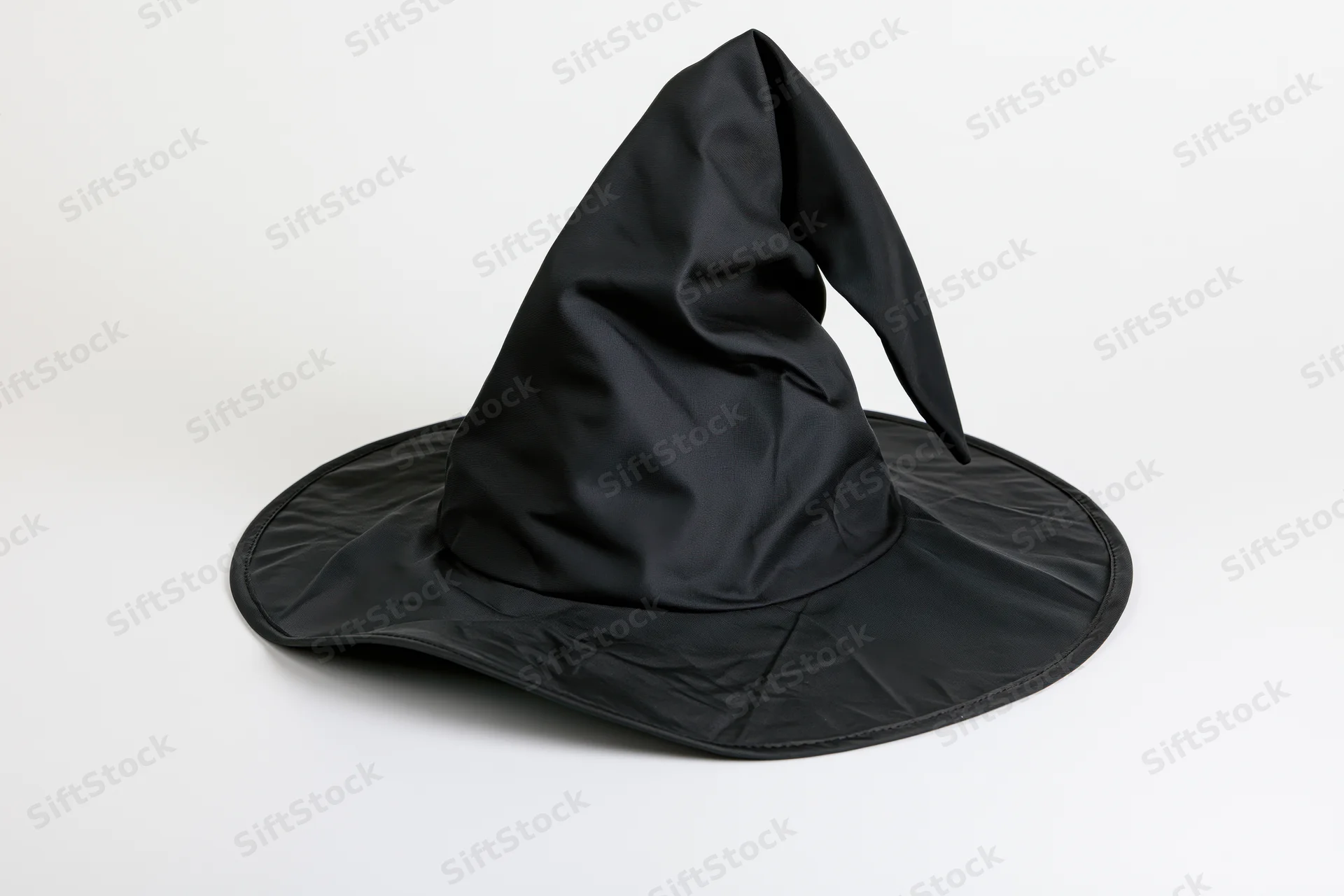 Black pointed witch hat with wide brim and slight bend on white background