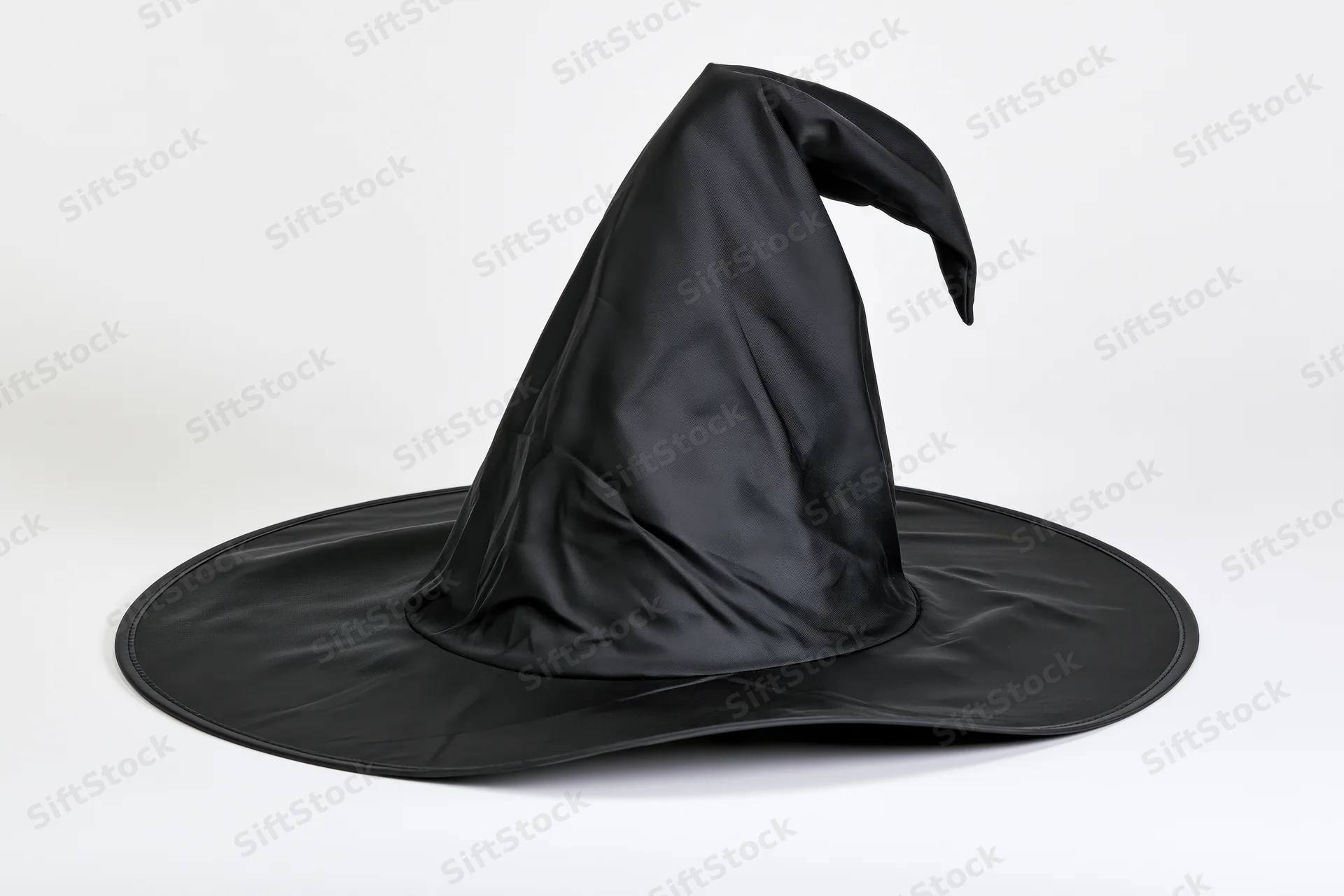 Black pointed witch hat with wide brim and bent tip on white background