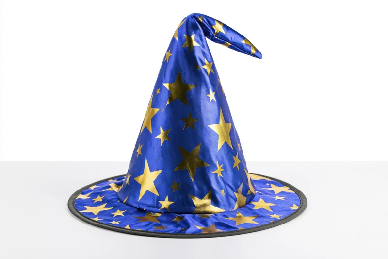 Blue wizard hat with gold stars on white surface