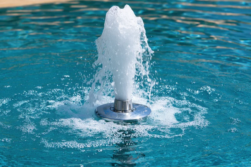 Chrome fountain jet spraying water in a swimming pool